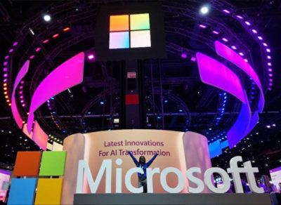 Microsoft booth with a large logo and colorful LED panels overhead, showcasing “Latest Innovations for AI Transformation.