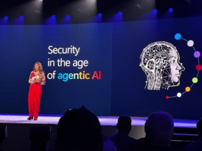 Speaker on stage with slide “Security in the age of agentic AI” and a head graphic.