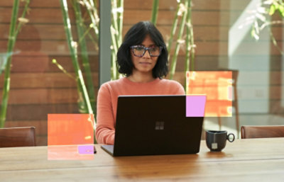 A woman in glasses using a laptop.