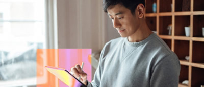 A person holding and looking at a tablet.