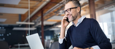 A man wearing glasses and talking on a cell phone.
