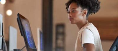 A person wearing a white shirt is looking at a computer screen.