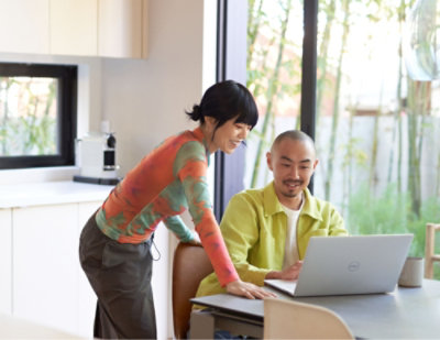 A man and woman looking at a laptop.