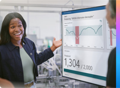 A woman points to a screen displaying various graphs, indicating data analysis or presentation.