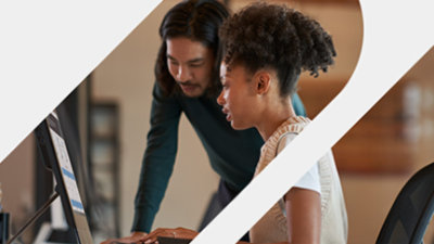 兩名專業人士，一男一女，在辦公室環境中的電腦前共同作業。