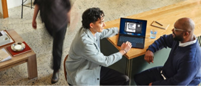 Un homme assis à une table avec un ordinateur portable.