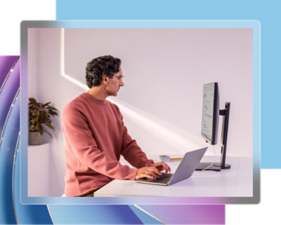 Personne assise à un bureau utilisant un ordinateur portable.