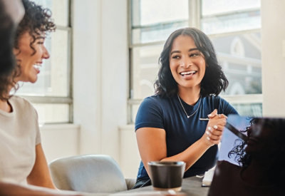 People seated around a table in a bright workspace, engaged in discussion