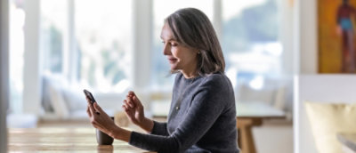 A person sitting at a table looking at their phone.