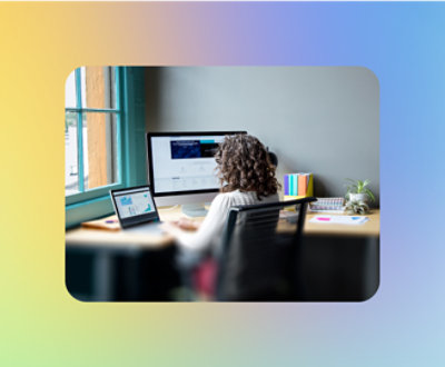 A person sitting at a desk looking at a computer