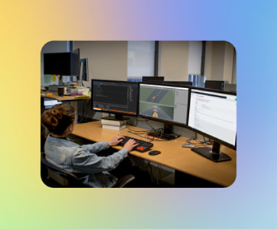A female software developer working at a multi-monitor setup in an office, coding and debugging software.