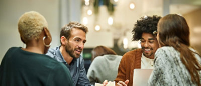 A group of people discussing and working on the laptop