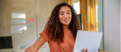 A women with curly hair with laptop in her hand