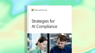 A man and woman sitting at a table with a computer.