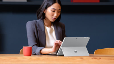 An adult woman working on Platinum Pro 13 and Pro Flex Keyboard in natural light.  
