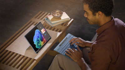 Man on bench with sapphire surface pro and keyboard.