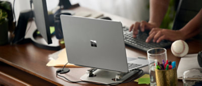 Hands typing on a keyboard beside a laptop