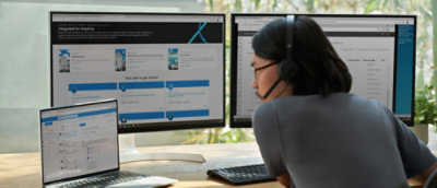 A person wearing headphones and looking at a computer screen.