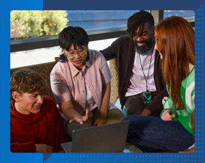 階段に座って、画面に青い抽象デザインを表示するラップトップを使用している 2 人。