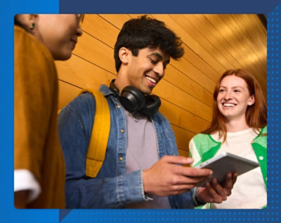 男性と子供が教室のテーブルでノート PCを使って一緒に作業をしています。子供は微笑んでいます。