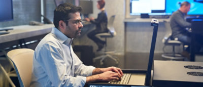 A man working on desktop screen in office.