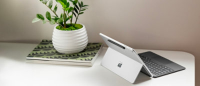 A white tablet on a desk with text reading AM visible on the screen.