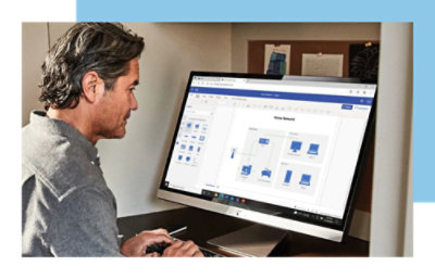 A person working on a computer, viewing a home network diagram on the screen in a modern office setting.
