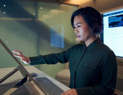 A women standing in front of a table using a desktop