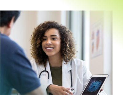 Žena sa kovrdžavom kosom u belom laboratorijskom mantilu drži tablet.