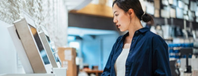 一名穿著藍色襯衫的女性正在查看一台機器。