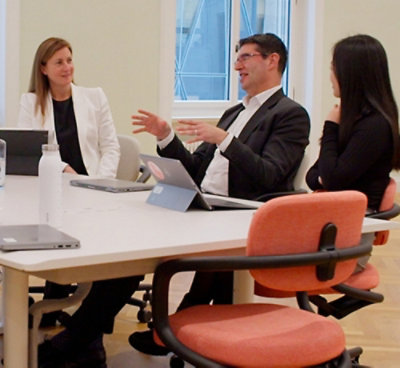 A man explaining something to two women.