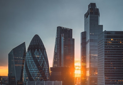 A group of tall buildings under a blue sky with clouds.