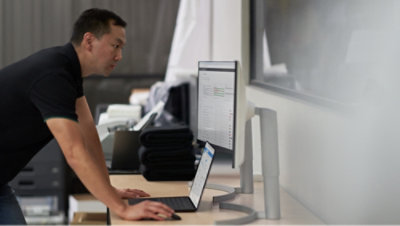 A person working on laptop with monitor