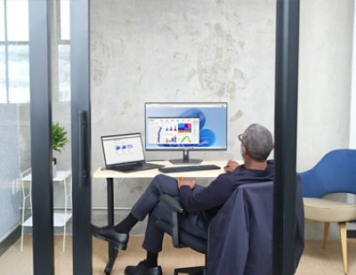 Man sitting in an office viewing Power BI UI within Windows 365.