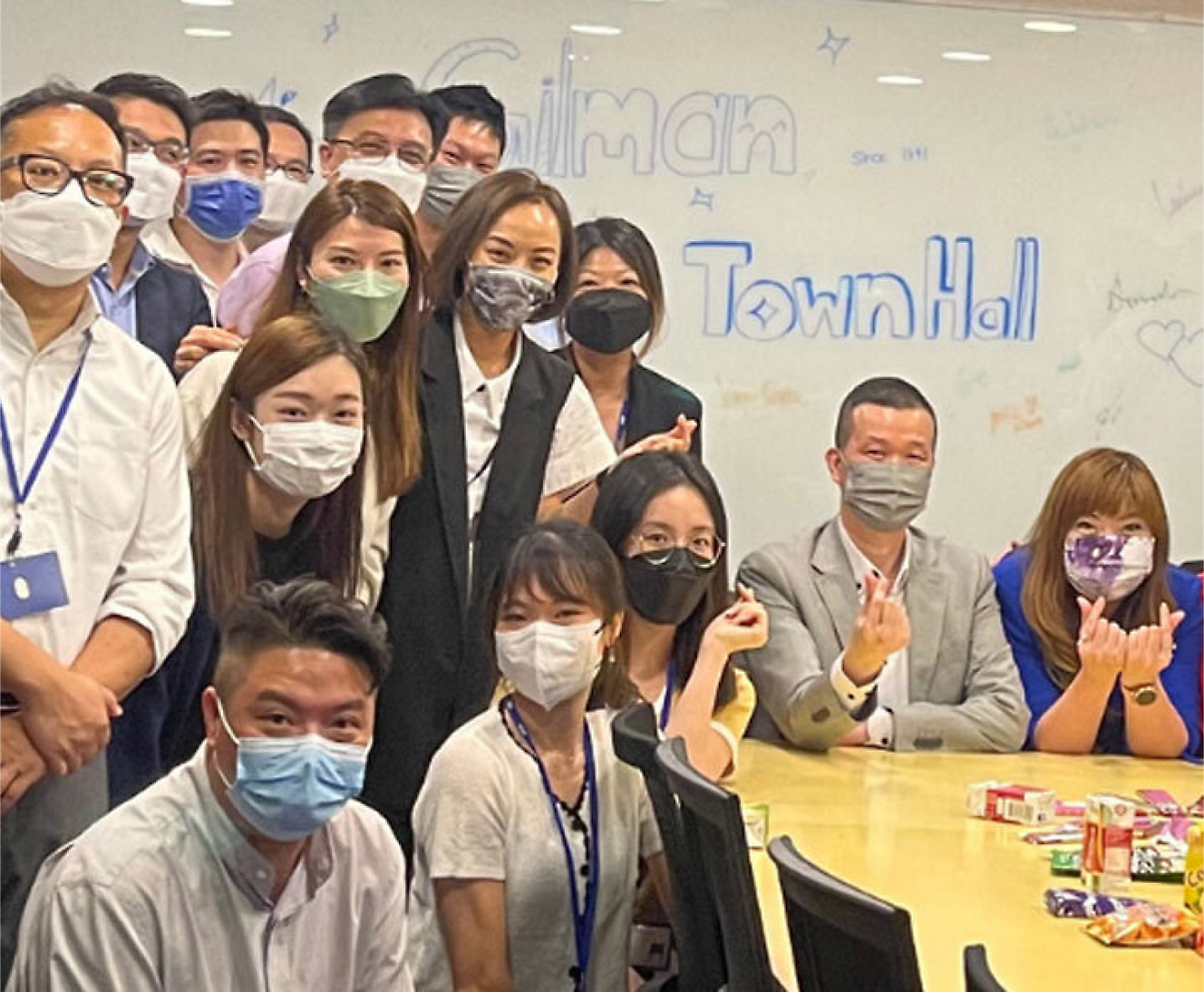 A group of people posing for a photo wearing face masks.