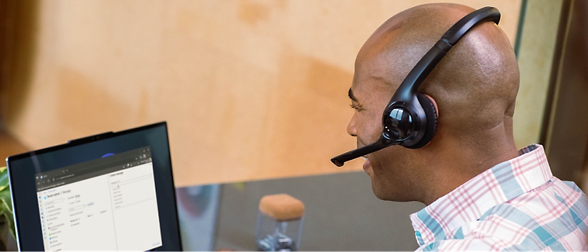 A man sitting at a desk wearing headset