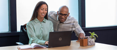 Two persons looking at the Dell laptop