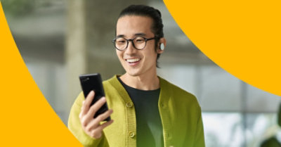 Osoba koja se smeje na mobilnom telefonu.