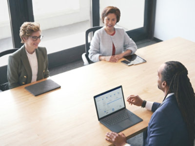 A man and 2 woman in business suit discussing with each other holding.