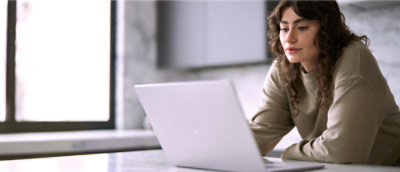 A woman is looking at a computer screen.