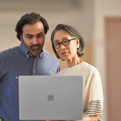 A man and woman looking at a laptop.