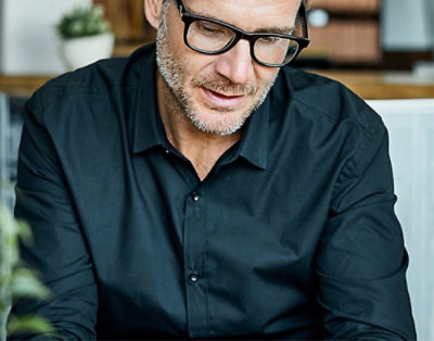 A close-up of a man's face wearing glasses.