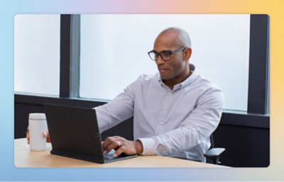 A person sitting at a desk using a laptop.