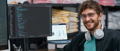 ヘッドホンを装着した笑顔の男性と、その横にある画面