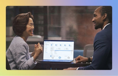 ノート PC の画面を見て話し合っている男性と女性