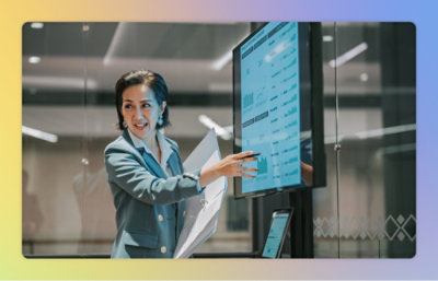 画面のデータを指し示しながら説明する女性