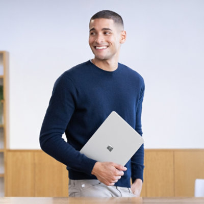 Eine Person, die einen Laptop hält.