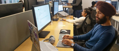 Mehrere Personen, die in einem Raum an Computern arbeiten