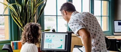 Ein Mann und eine Frau, die auf einen Computerbildschirm blicken