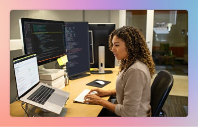 Eine Frau sitzt an einem Tisch und benutzt einen Computer.